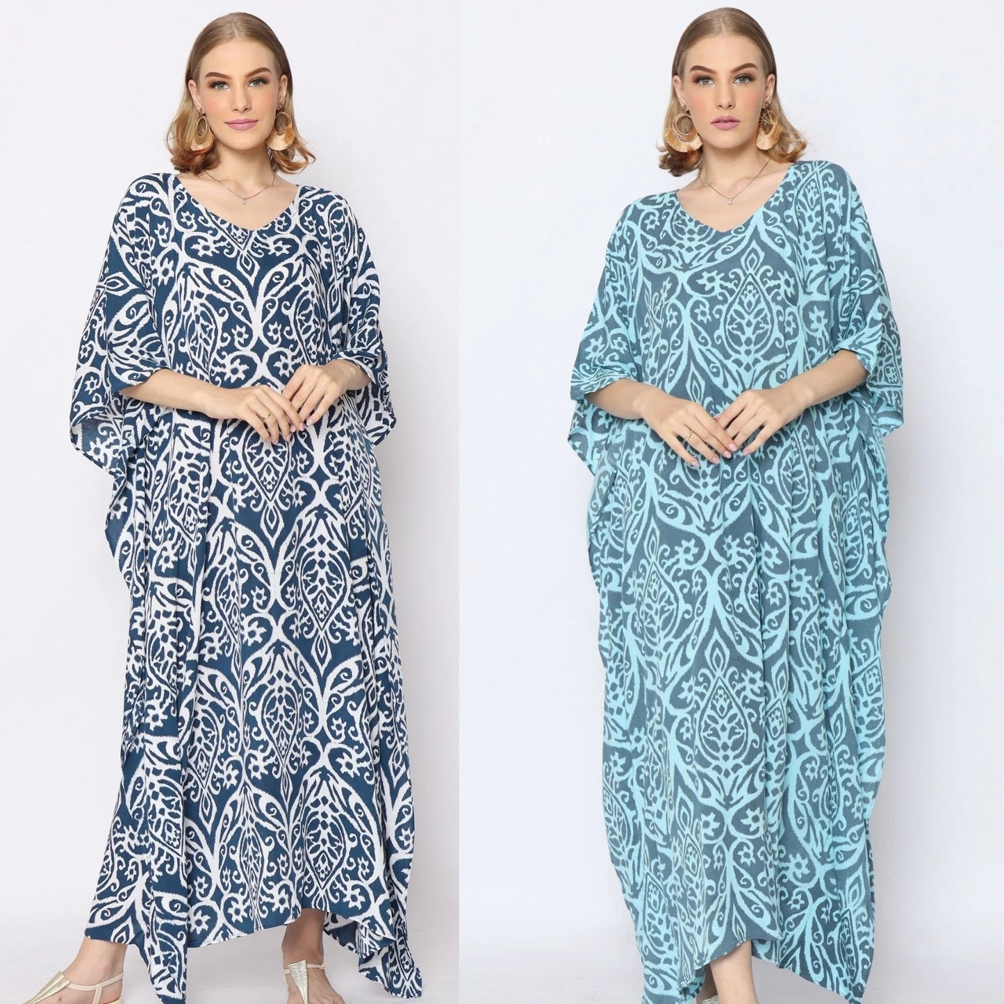 Two women stand side by side, each wearing a patterned caftan. The woman on the left wears a dark blue and white design, while the woman on the right sports a light blue version. Both have similar hairstyles and poses against a plain background.